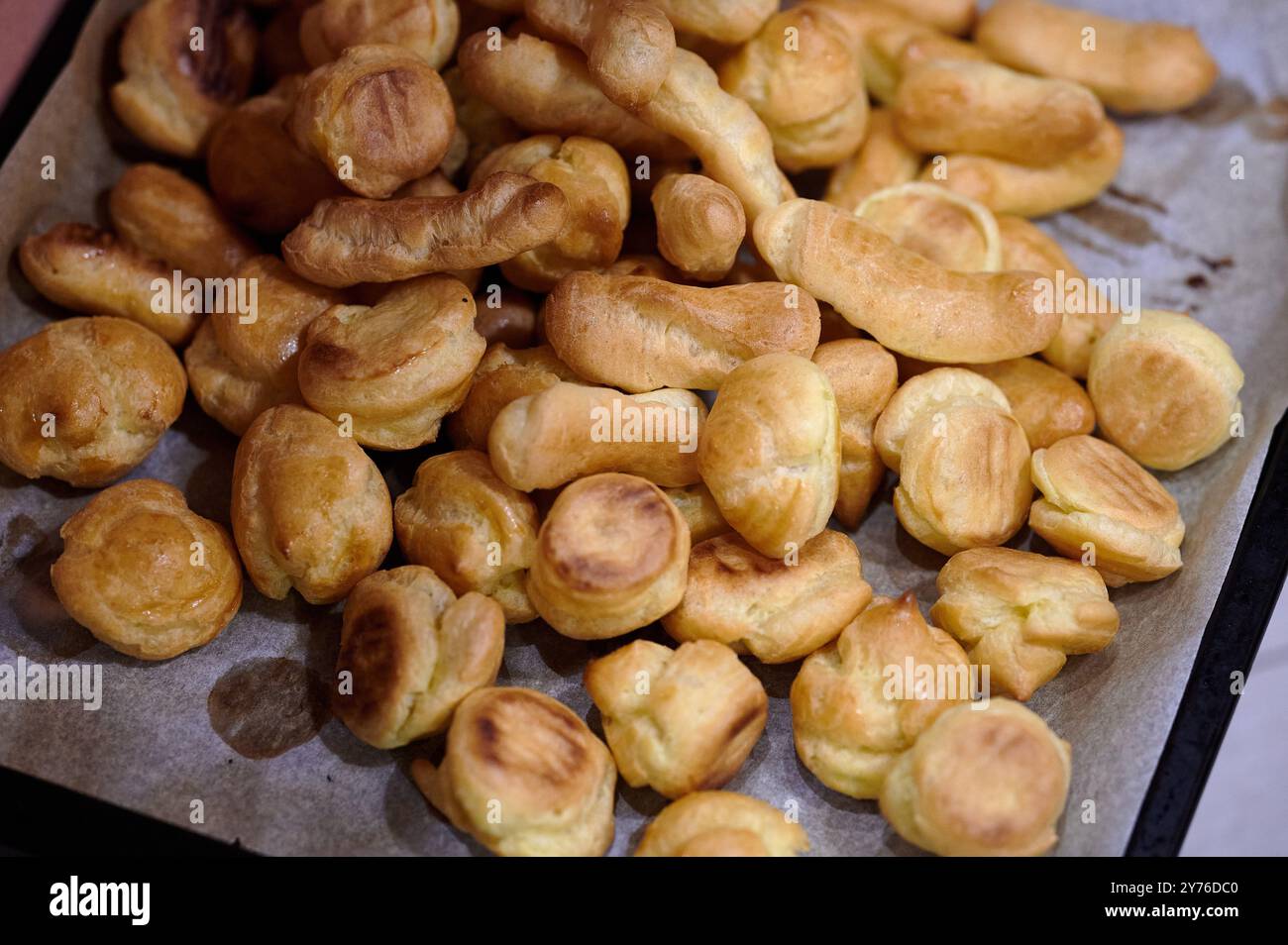 Vassoio pieno di pirogi o gnocchi dorati appena sfornati dal forno in cucina o in panetteria Foto Stock