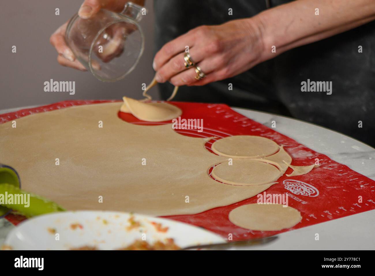 Una donna scolpisce gli gnocchi dall'impasto. Foto Stock