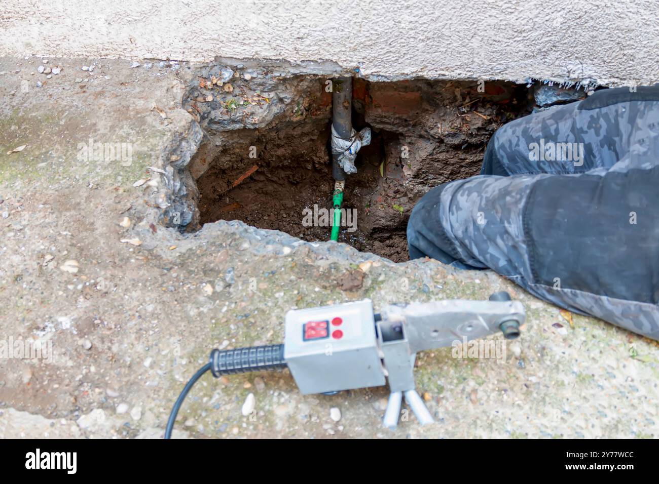 Il tubo è rotto o scoppiato. L'acqua fuoriesce dal sistema di tubazioni e viene riparata Foto Stock