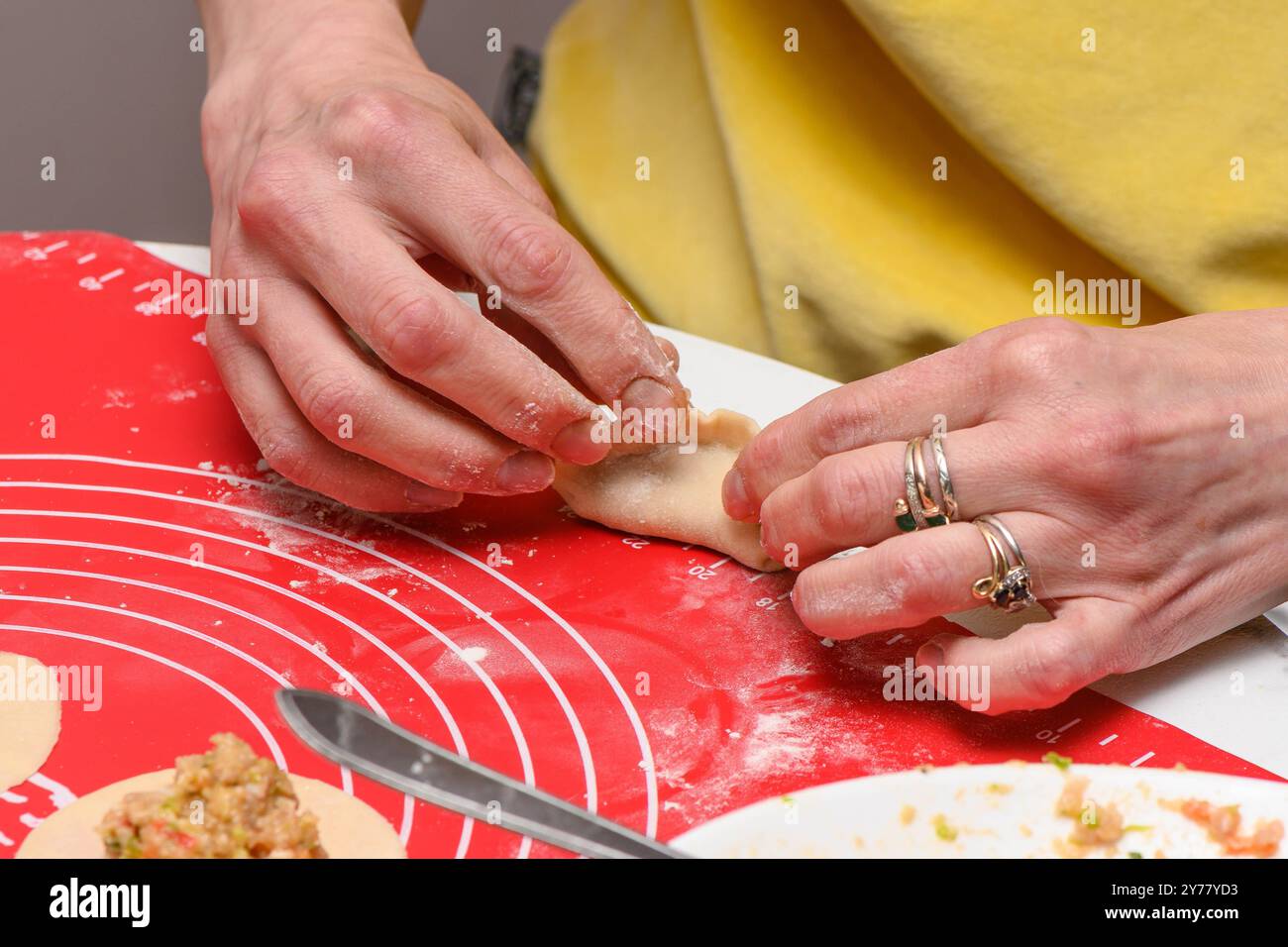 Una donna scolpisce gli gnocchi dall'impasto. 7 Foto Stock