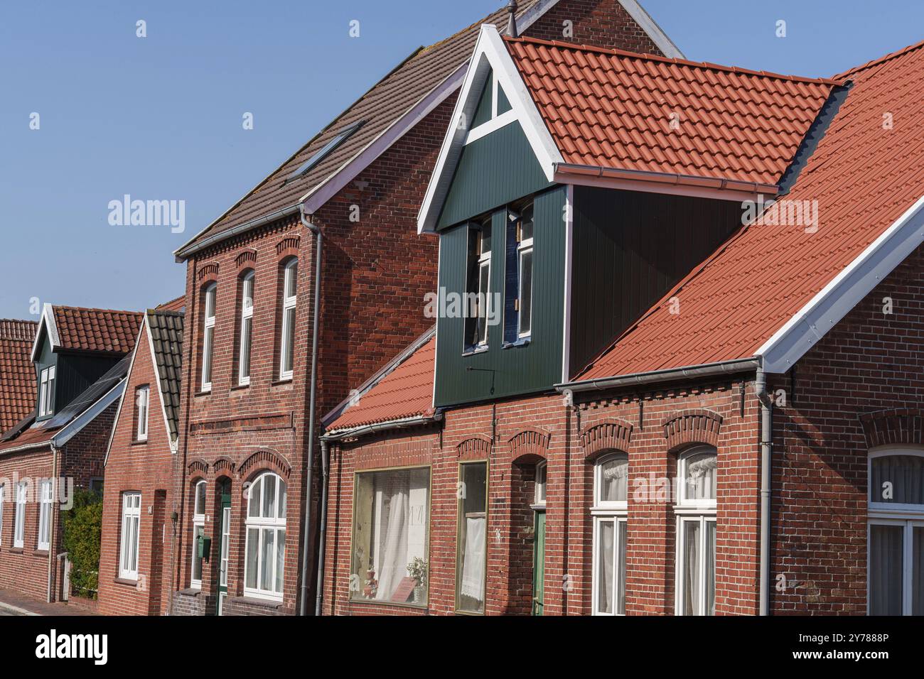 Strada con tradizionali case in mattoni e tetti caratteristici, Ditzum, Frisia orientale, Germania, Europa Foto Stock