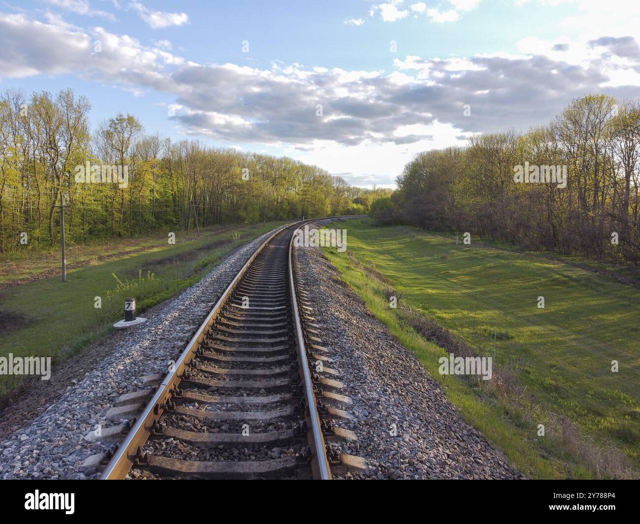 Ferrovia, sentieri attraverso la piantagione di alberi, erba verde e splendida natura, viaggia attraverso steppe e foreste ucraine Foto Stock