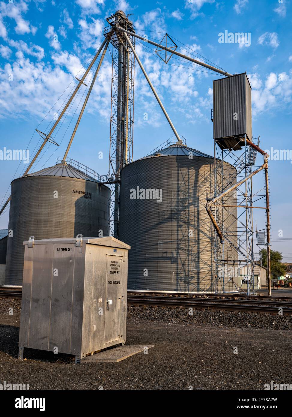 Un capannone per apparecchiature di segnalazione BNSF e contenitori per cereali metallici ondulati presso i binari ferroviari di Odessa, Washington, USA Foto Stock