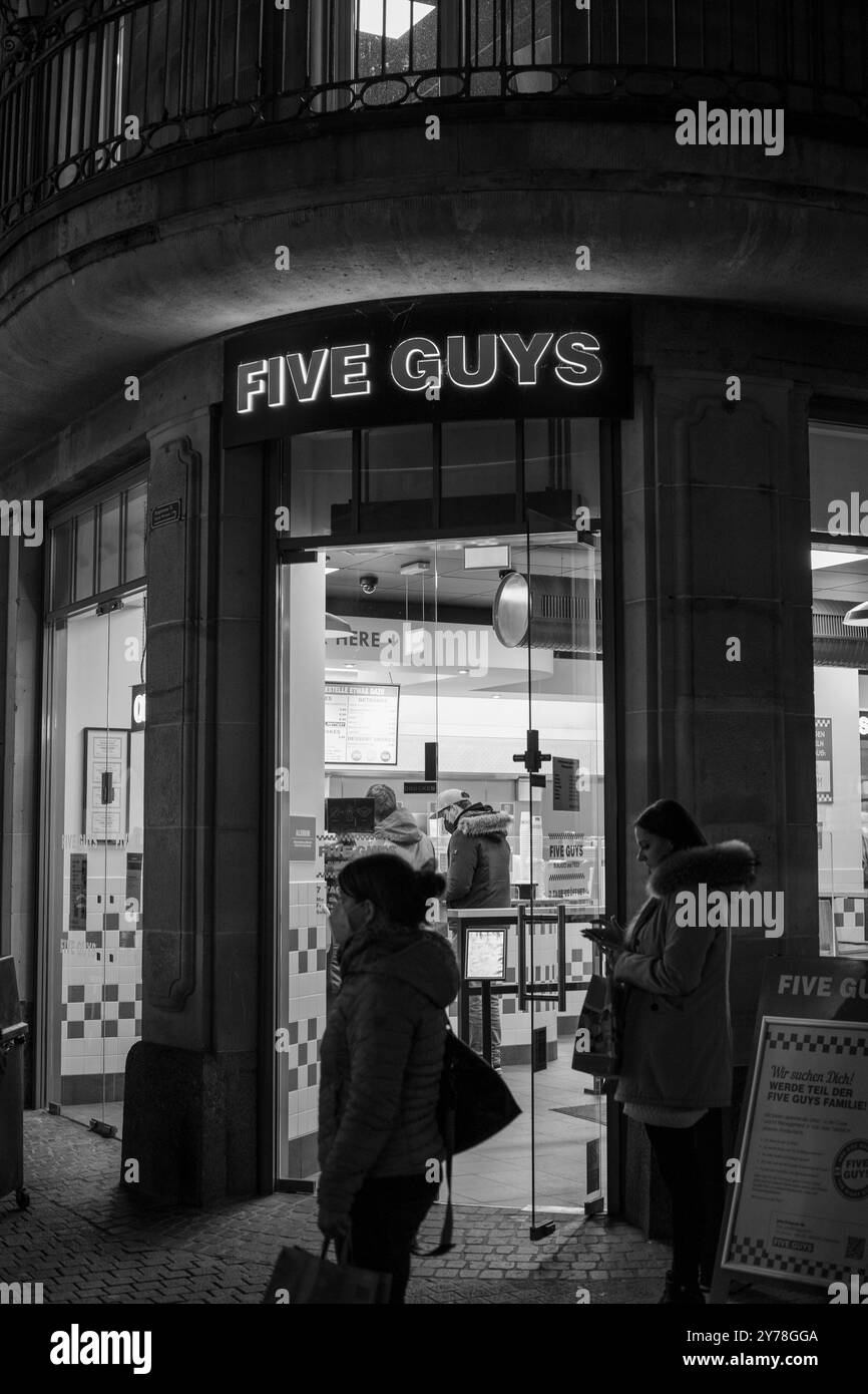 Foto in bianco e nero di persone in piedi di fronte al ristorante in attesa di ordinare durante la pandemia di covid Foto Stock