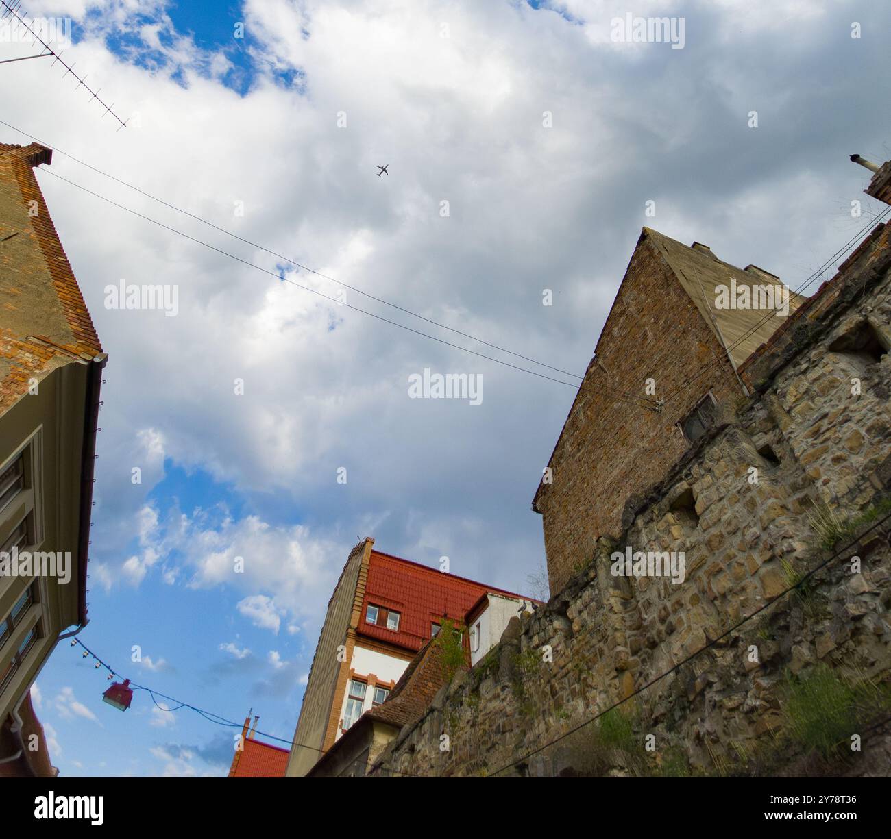 Cluj-Napoca, Romania. 26 aprile 2024: Un aereo passeggeri commerciale vola sul cielo sopra la parte del muro di difesa (XV secolo) del m Foto Stock Cluj-Napoca, Romania. 26 aprile 2024: Un aereo passeggeri commerciale vola sul cielo sopra la parte del muro di difesa (XV secolo) del m Foto Stock