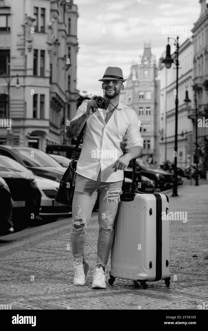 Studente viaggiatore o giovane turista. Uomo viaggiatore con valigia all'aperto. Turista che ha viaggio di vacanza. Foto Stock