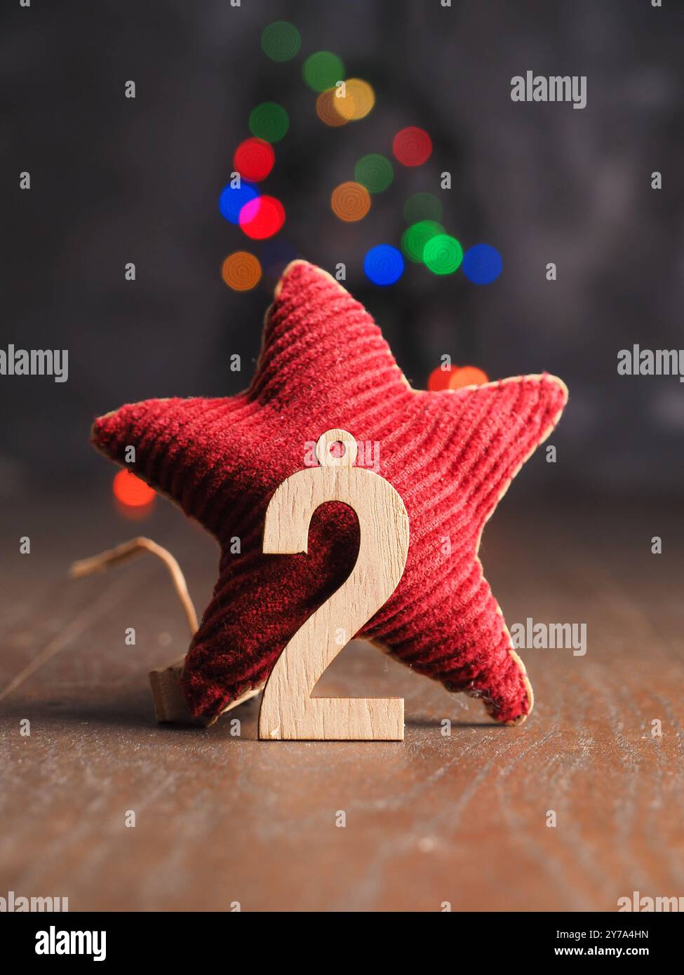 Il secondo dicembre è in legno numero uno con cono di pino su luci di Natale sfocate Foto Stock