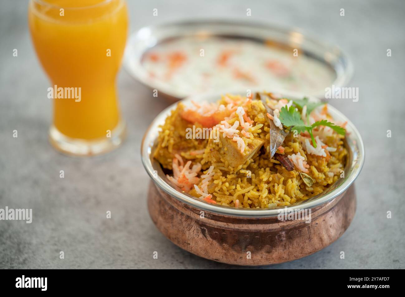 Pulao biryani indiano piccante in ciotola dorata con riso basmati indiano con curry di carne di pollo Ramadan Kareem, Eid. Recipiente da portata in ottone con dorso bianco Foto Stock