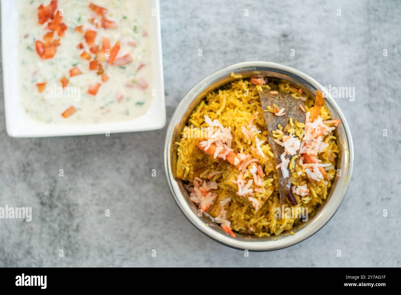 Pulao biryani indiano piccante in ciotola dorata con riso basmati indiano con curry di carne di pollo Ramadan Kareem, Eid. Recipiente da portata in ottone con dorso bianco Foto Stock