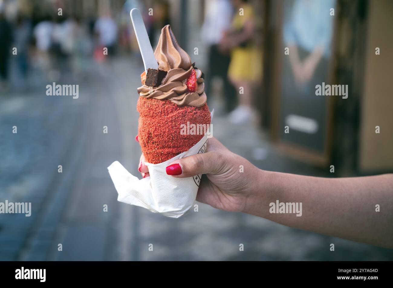 Trdelnik o trdlo è un dolce tradizionale ceco. Donna tiene a mano il trdlo in via Praga. Cibo di strada. Trdelnik è una torta dolce tradizionale con zucchero An Foto Stock
