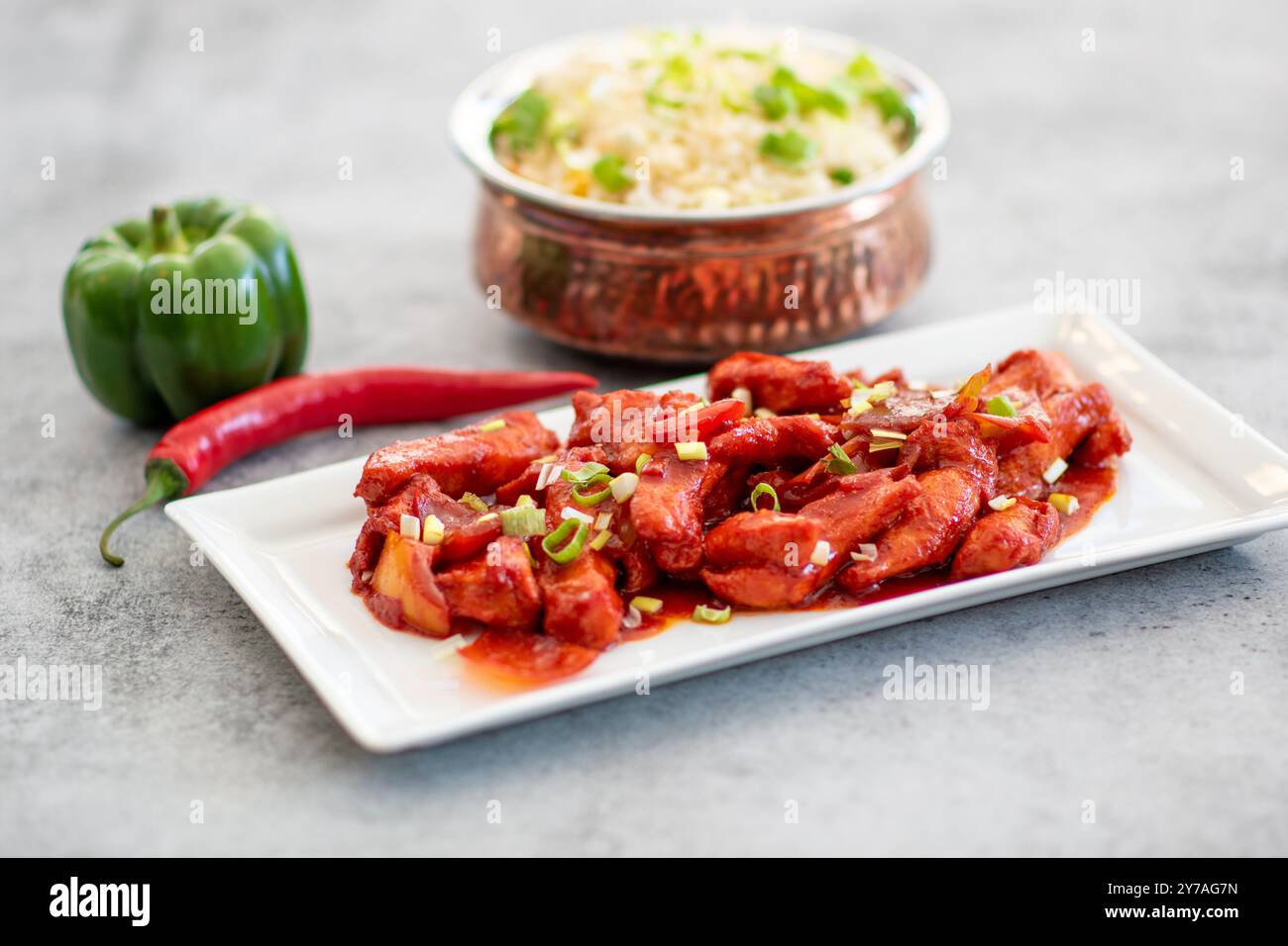 Delizioso pollo allo zenzero con miele e soia sul piatto su sfondo di pietra scura. Ricetta asiatica, vista dall'alto. Vista ravvicinata del copyspace. Foto Stock