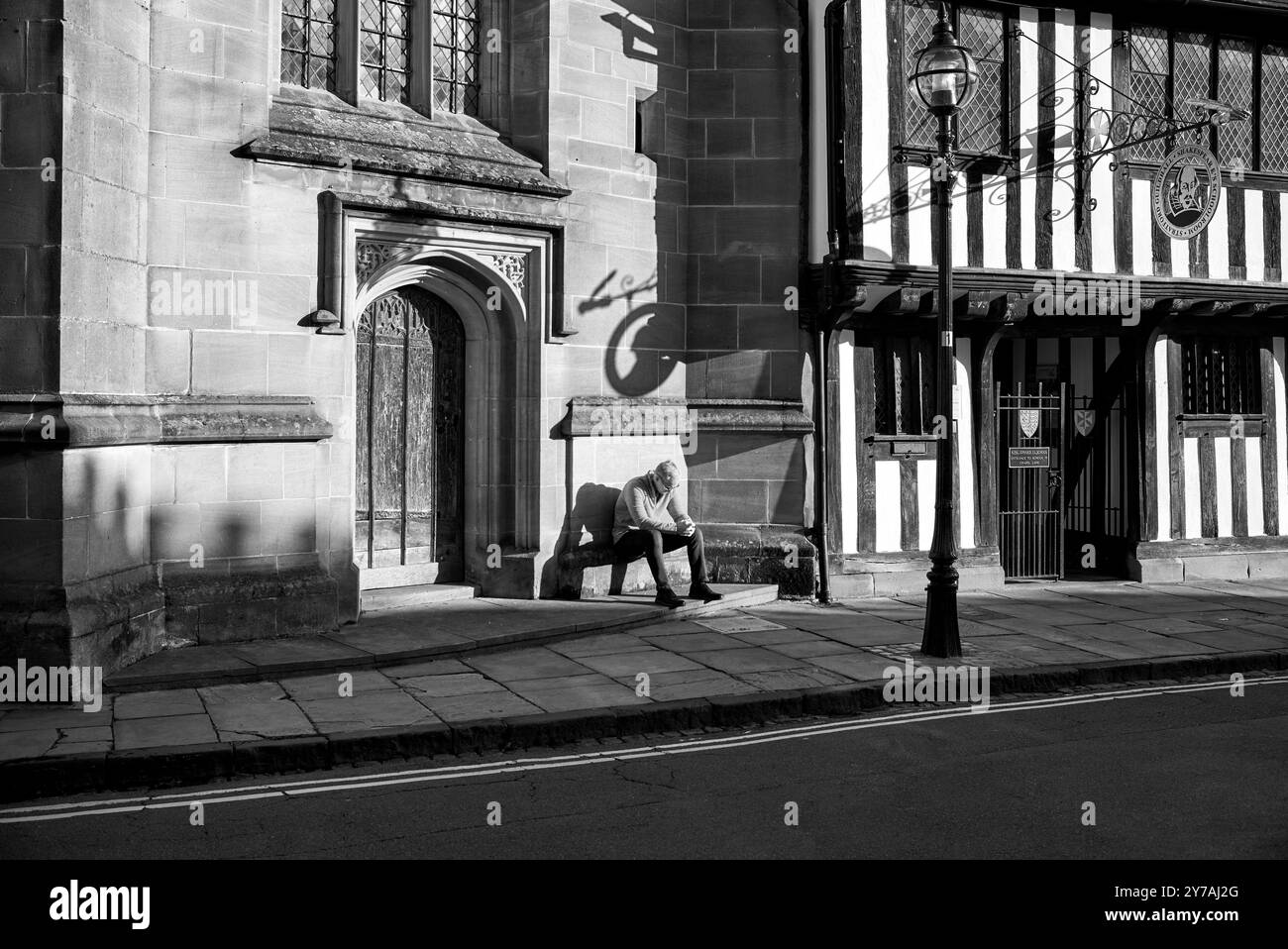 Fotografa in bianco e nero. Uomo da solo, profondo nel pensiero e nella contemplazione, alla Guild Chapel Stratford Upon Avon, Inghilterra, Regno Unito, Foto Stock