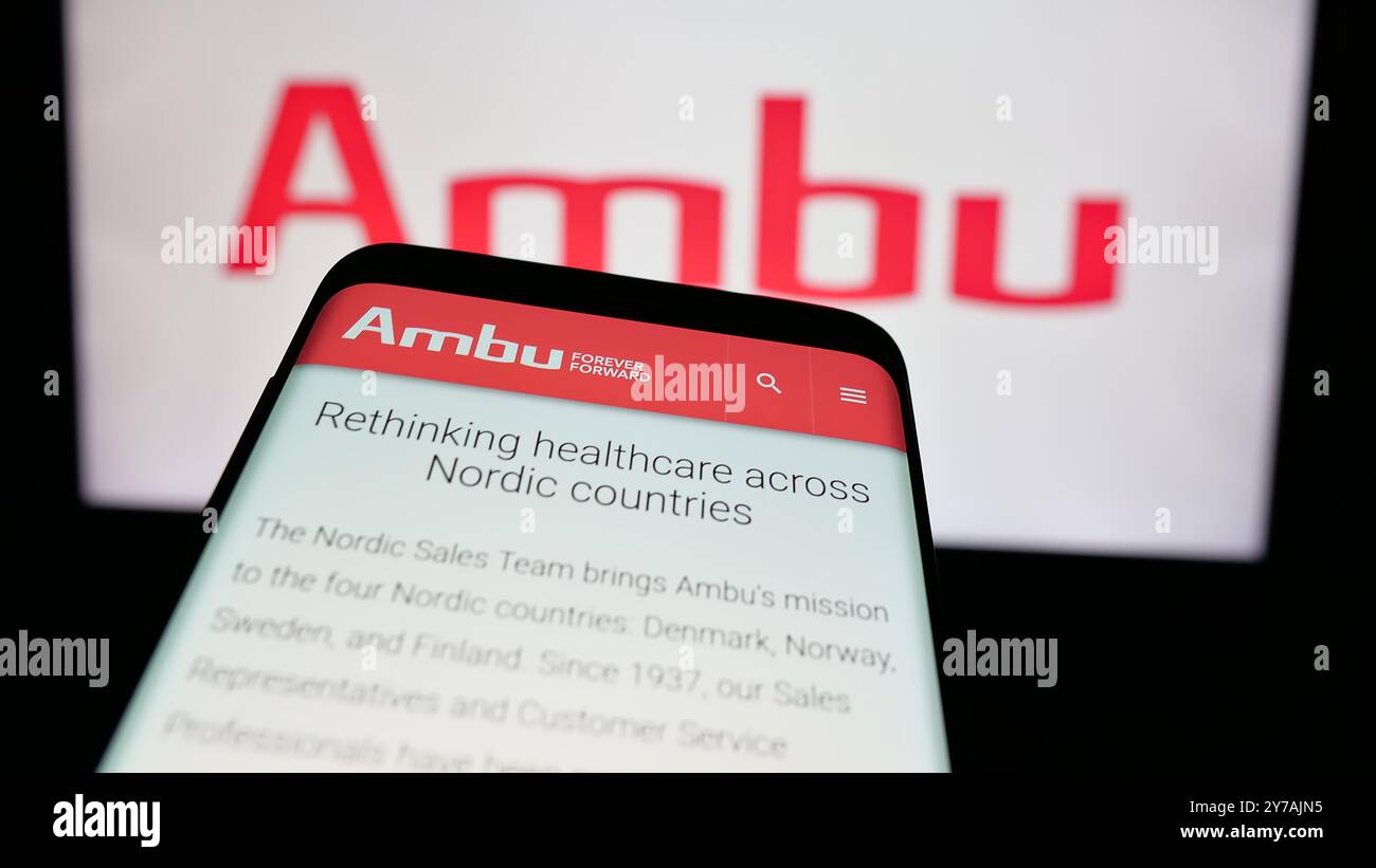 Telefono cellulare con sito web della società danese di tecnologia medica Ambu COME sullo schermo di fronte al logo aziendale. Mettere a fuoco in alto a sinistra sul display del telefono. Foto Stock