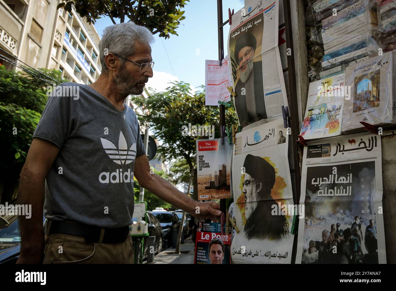 Beirut, Libano. 29 settembre 2024. Un uomo guarda i quotidiani libanesi che riportano le immagini del capo filo-iraniano Hassan Nasrallah ucciso con slogan che recitano: "Sayed Nasrallah·on the Road to Jerusalem" e "IT's the Total War". Crediti: Marwan Naamani/dpa/Alamy Live News Foto Stock