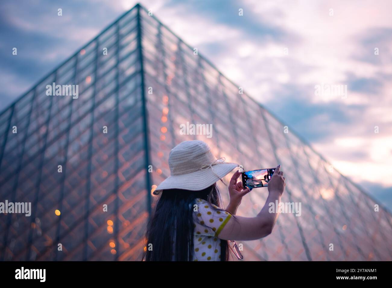 Una bella donna che scatta foto di fronte al Museo del Louvre, uno dei musei più grandi del mondo e un monumento storico. Un punto di riferimento centrale di Pa Foto Stock