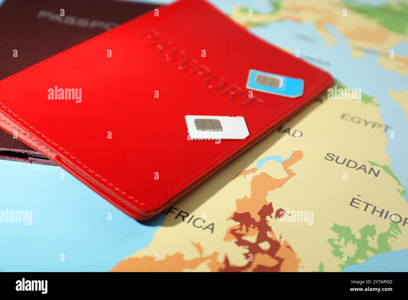 Schede SIM e passaporti moderni sulla mappa del mondo, primo piano Foto Stock