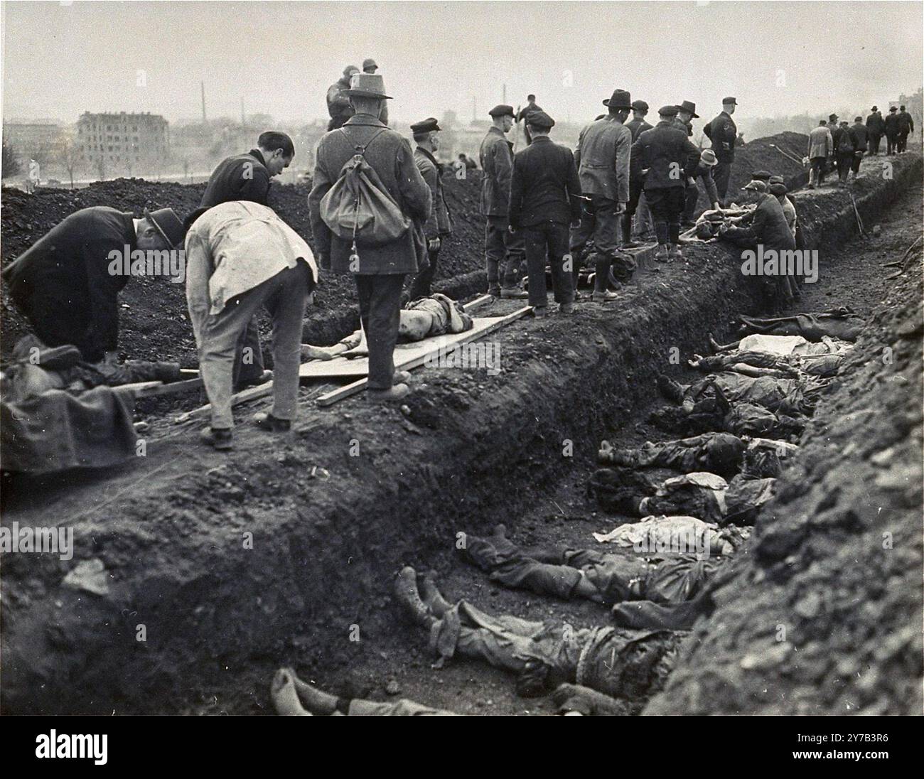 I civili tedeschi della città di Nordhausen seppelliscono i corpi degli ex prigionieri trovati nel campo di concentramento di Nordhausen in una fossa comune. Azioni come questa facevano parte del processo di denazificazione. Questo processo fu un tentativo di liberare la cultura e la società tedesca e austriaca dall'influenza e dall'ideologia nazista. Una parte del processo prevedeva di affrontare il pubblico con le prove dei crimini commessi nella loro zona. Foto Stock