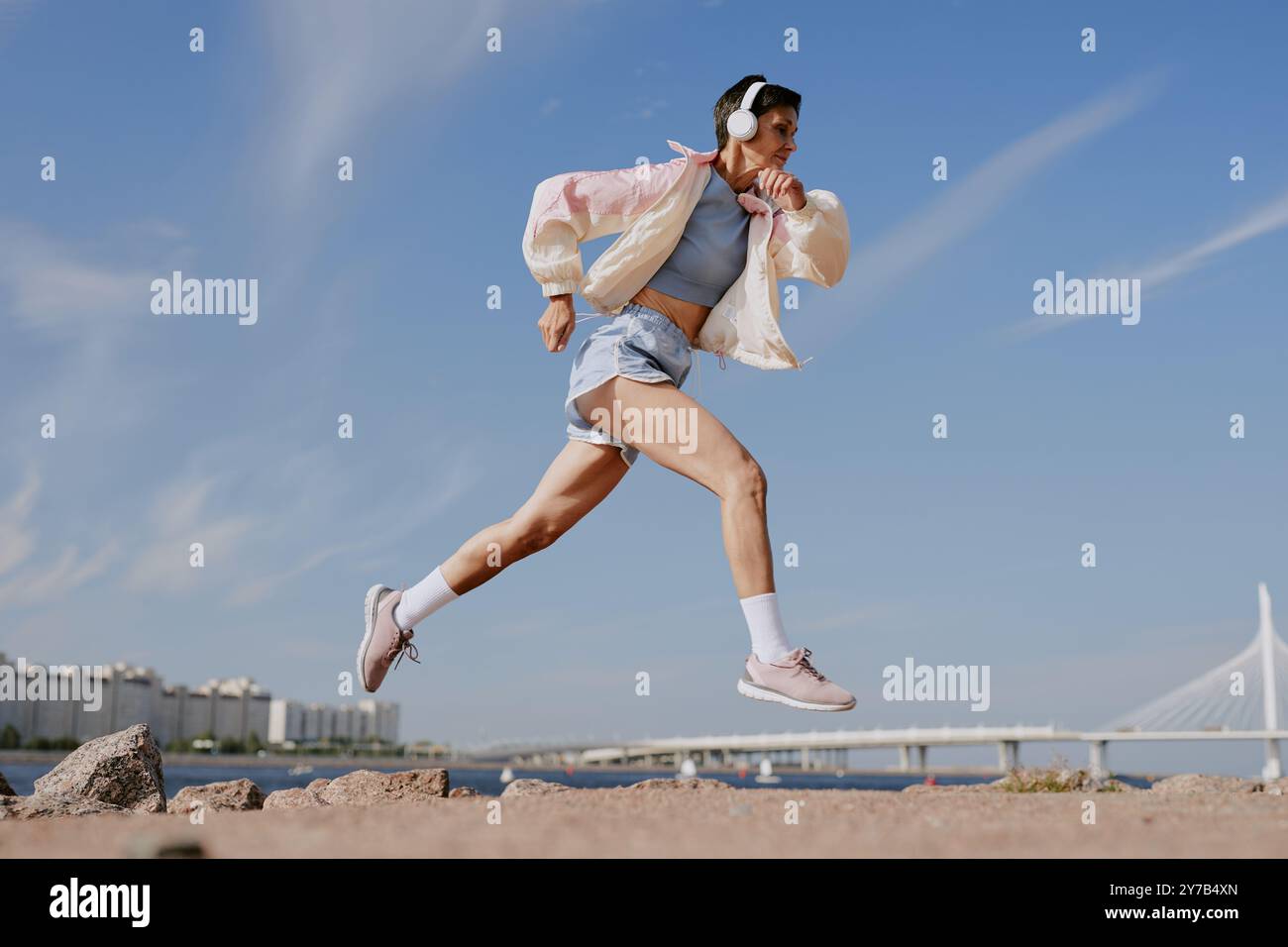 Scatto ad angolo basso di schegge femmina anziana che corre sulla costa Foto Stock