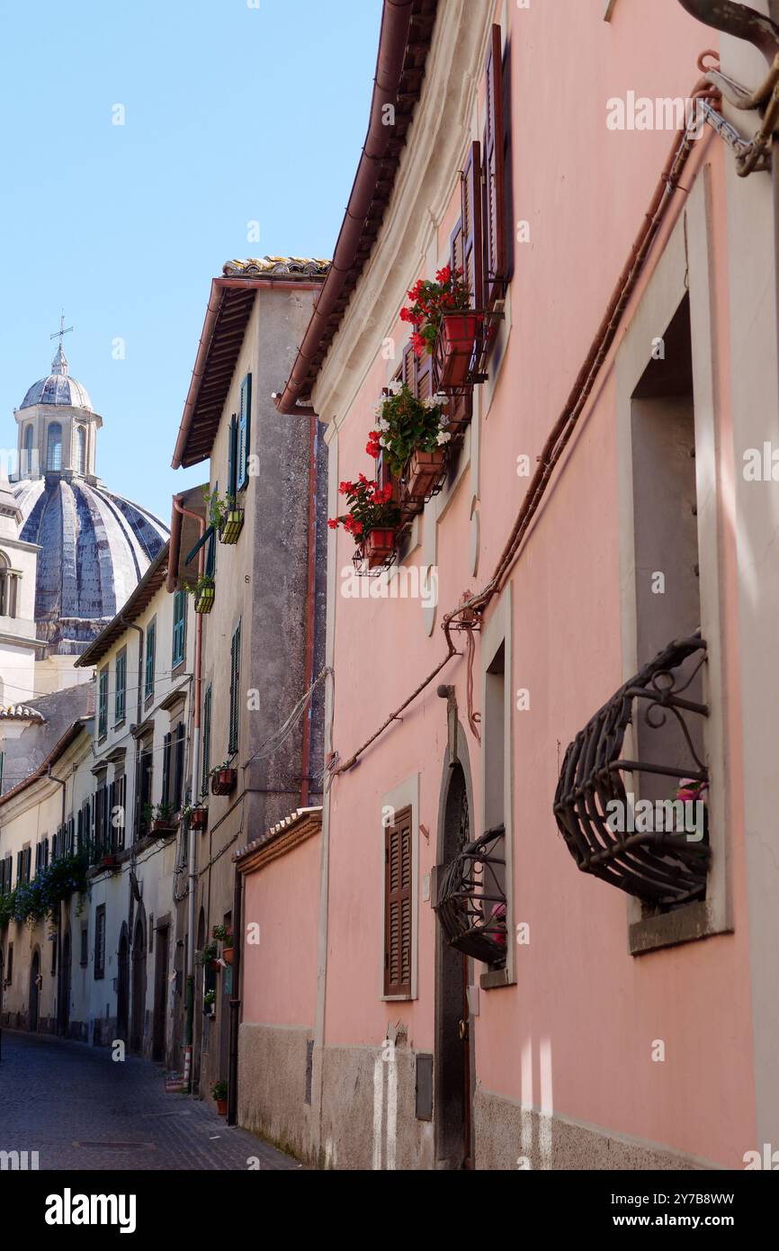 Strada stretta con fiori e cupola del Duomo nel centro storico della città di Montefiascone, Lazio, Italia. Settembre 28/29 2024 Foto Stock