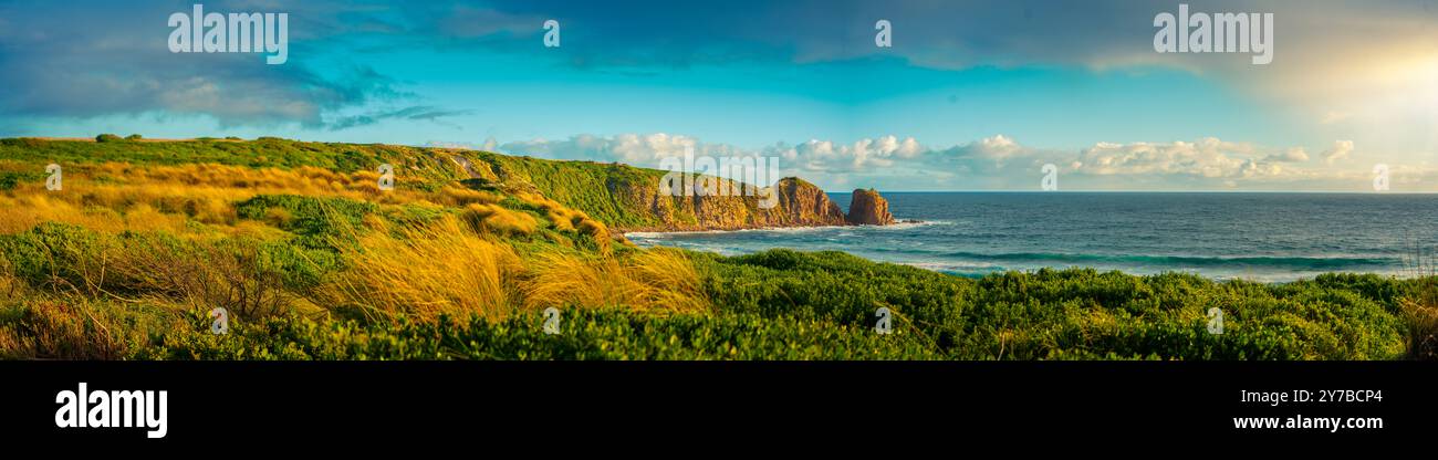 Panorama della spiaggia di Cape Woolamai che mostra la formazione rocciosa dei Pinnacoli al tramonto, Phillip Island, Australia. La luce dorata del sole splende sul Foto Stock