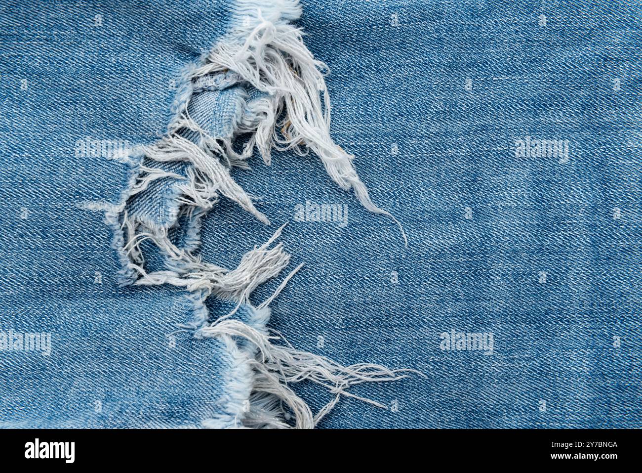 Texture jeans strappati. Sfondo denim con frange Foto Stock