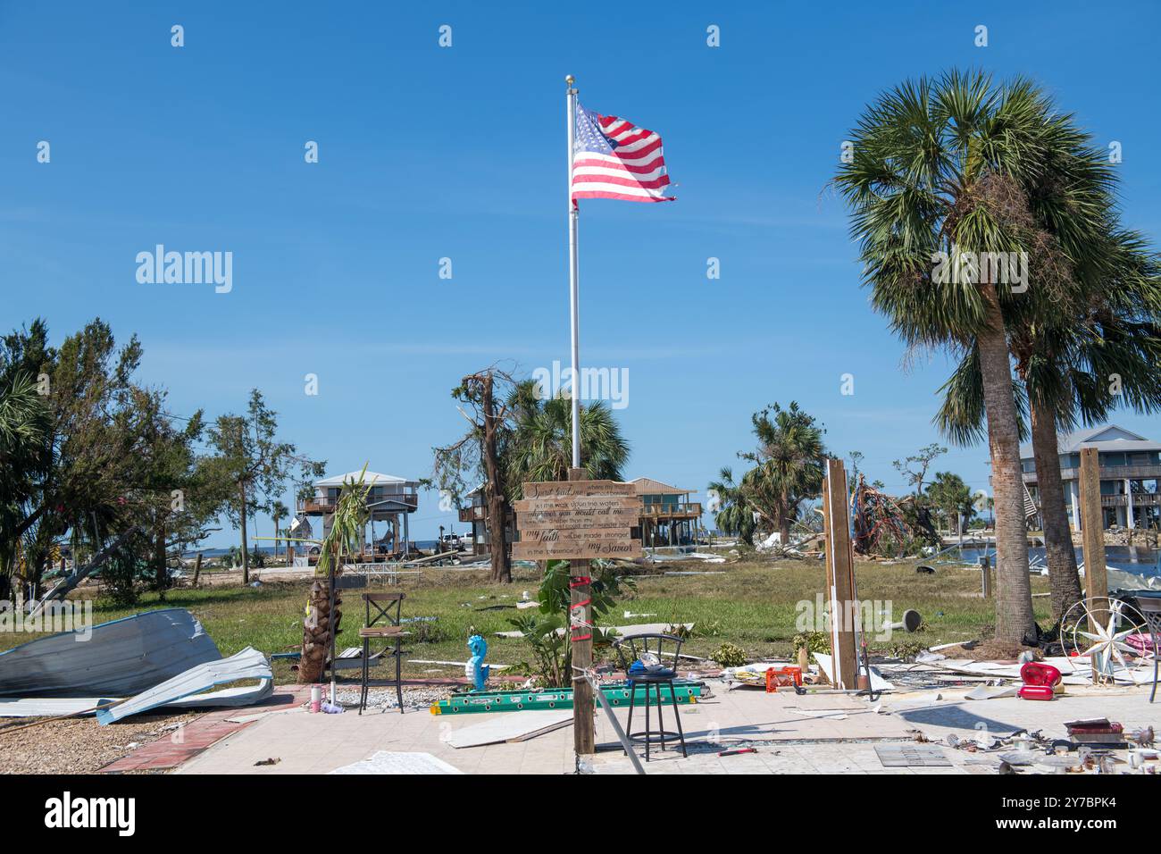 Keaton Beach, Stati Uniti. 28 settembre 2024. Una bandiera americana vola sopra un memoriale improvvisato tra i detriti in seguito all'uragano Helene, il 28 settembre 2024 a Keaton Beach, Florida. Keaton Beach ha ricevuto il peso della massiccia tempesta di categoria 4 distruggendo circa il 90% delle case e delle proprietà. Credito: SSgt. Jacob Hancock/US Air Force/Alamy Live News Foto Stock