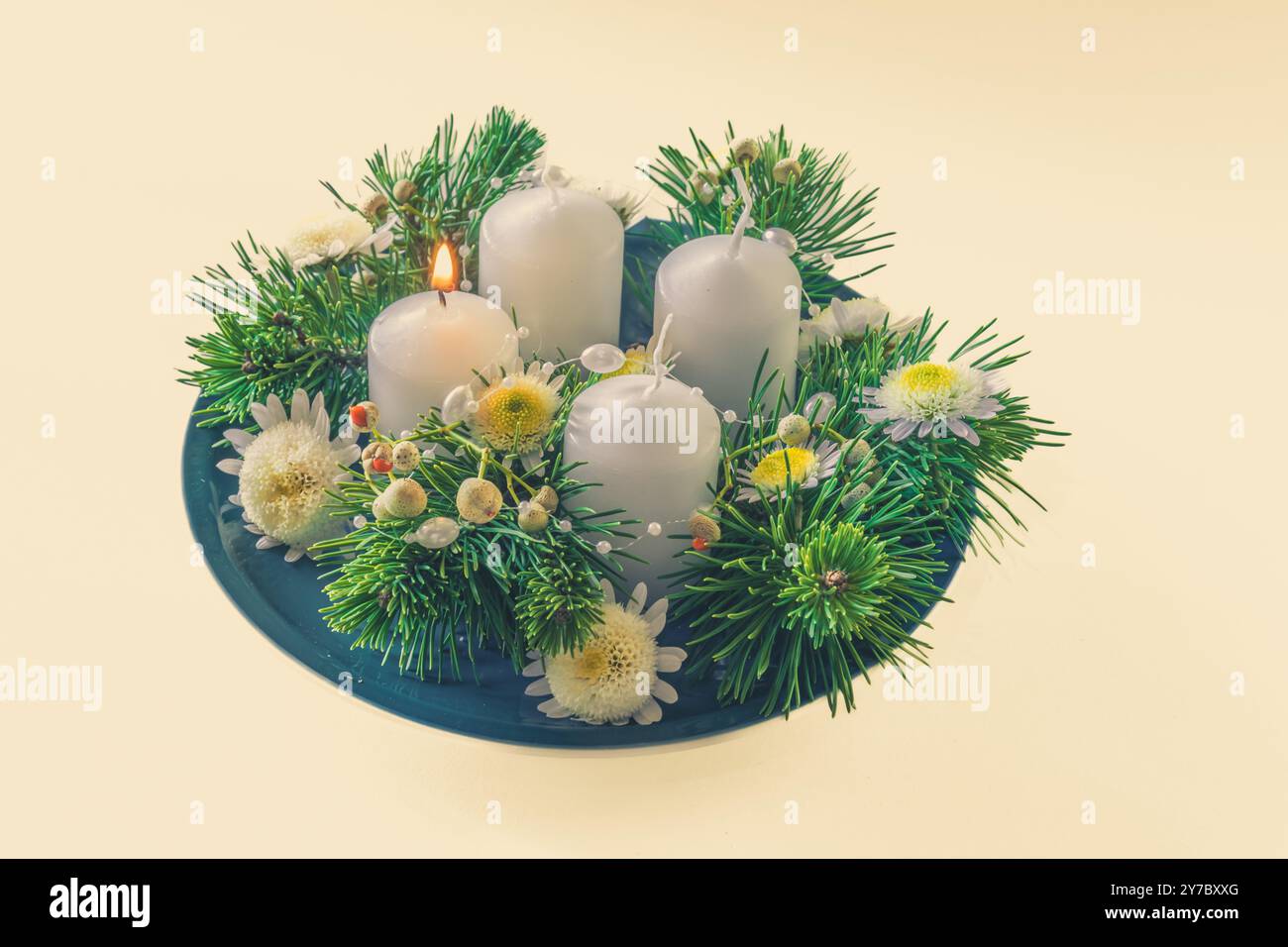 quattro candele bianche dell'avvento, decorazioni a corona con fiori e pini, isolate, candele del primo avvento accese Foto Stock