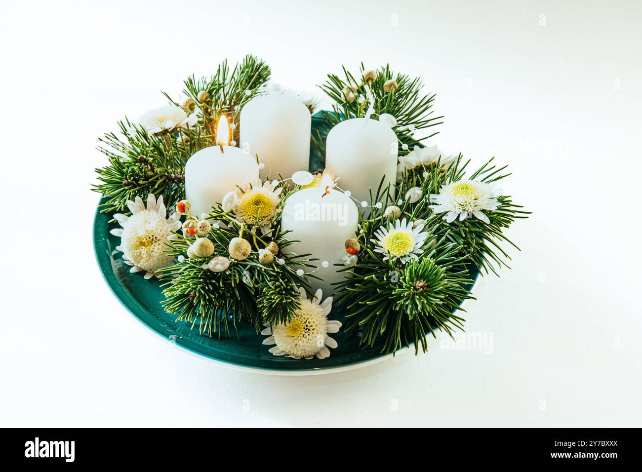 quattro candele bianche dell'avvento, decorazioni a corona con fiori e pino, isolate, candele del secondo avvento accese Foto Stock