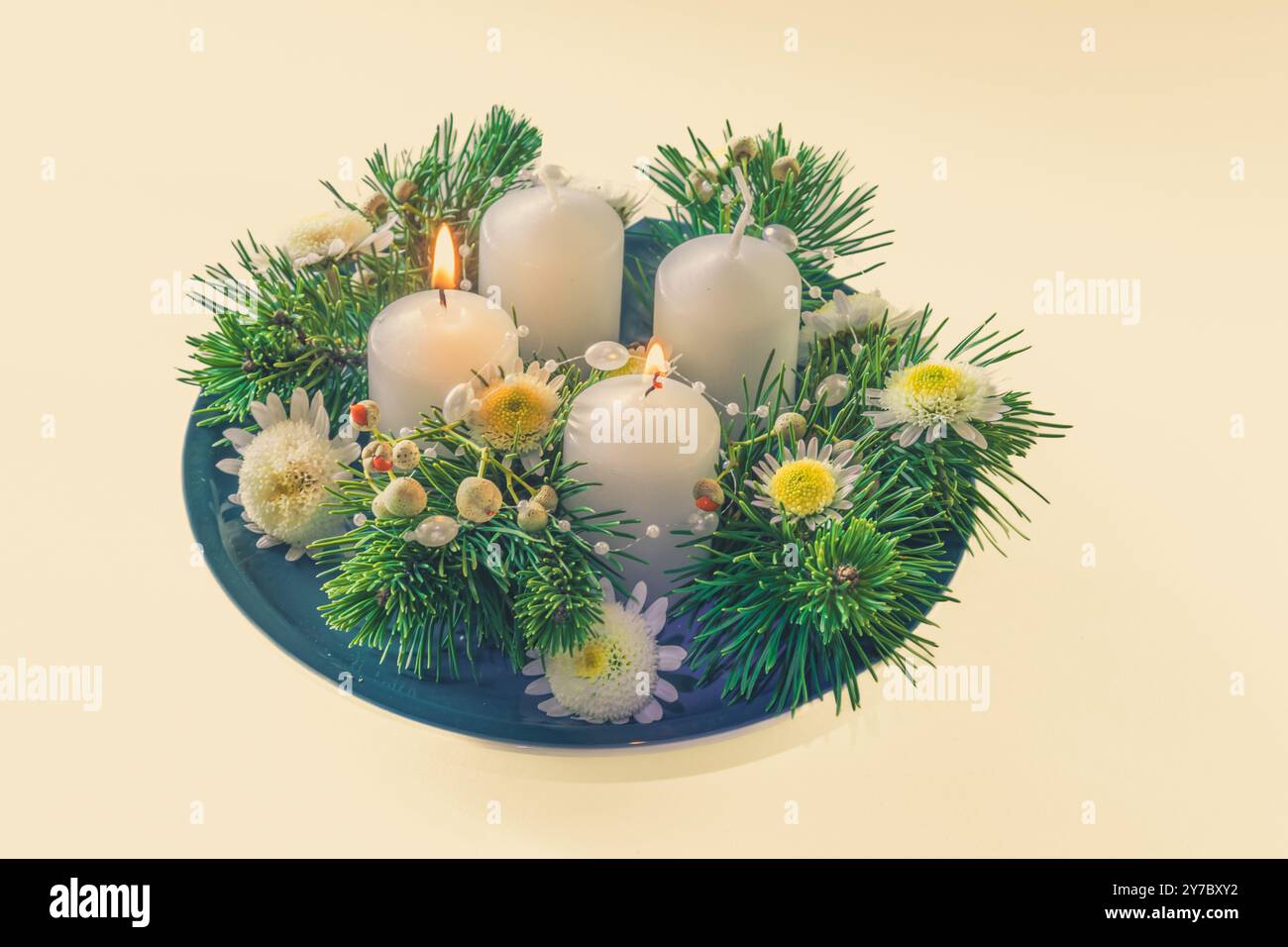 quattro candele bianche dell'avvento, decorazioni a corona con fiori e pino, isolate, candele del secondo avvento accese Foto Stock