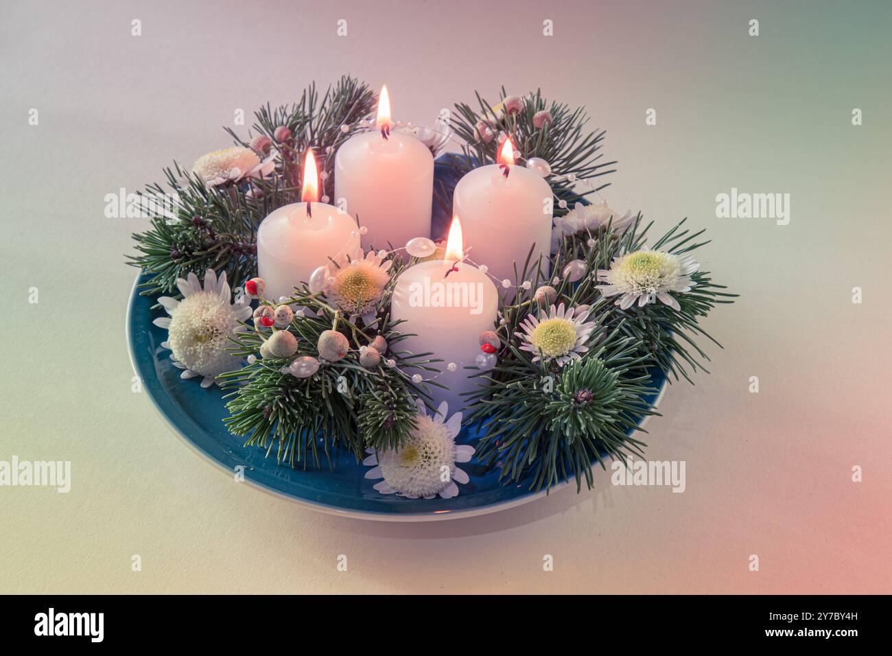 quattro candele bianche dell'avvento, decorazioni a corona con fiori e pini, isolate, quattro candele dell'avvento accese Foto Stock