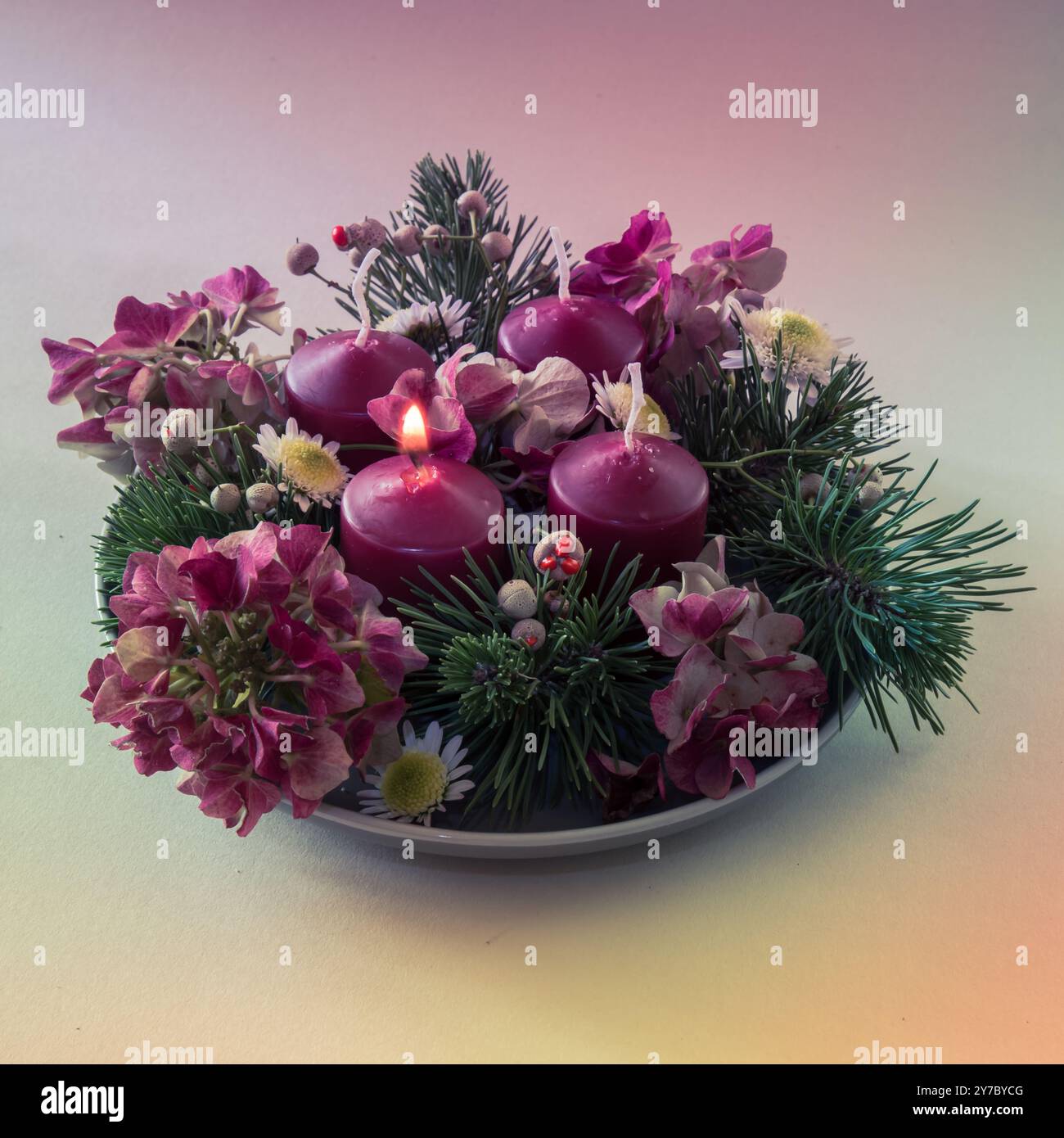 quattro candele bianche dell'avvento, decorazioni a corona con fiori e pini, isolate, una candela dell'avvento bruciata Foto Stock