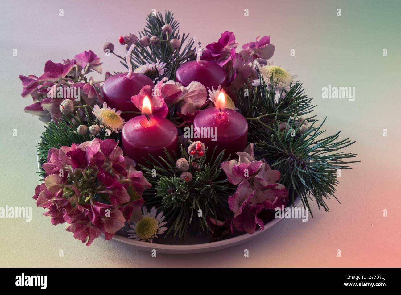 quattro candele bianche dell'avvento, decorazioni a corona con fiori e pino, isolate, due candele dell'avvento in fiamme Foto Stock