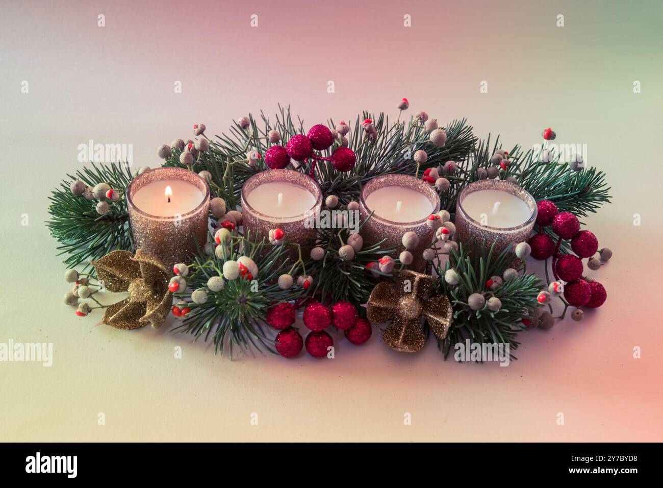 quattro candele bianche dell'avvento, decorazioni a corona con fiori e pini, isolate, una candela dell'avvento bruciata Foto Stock