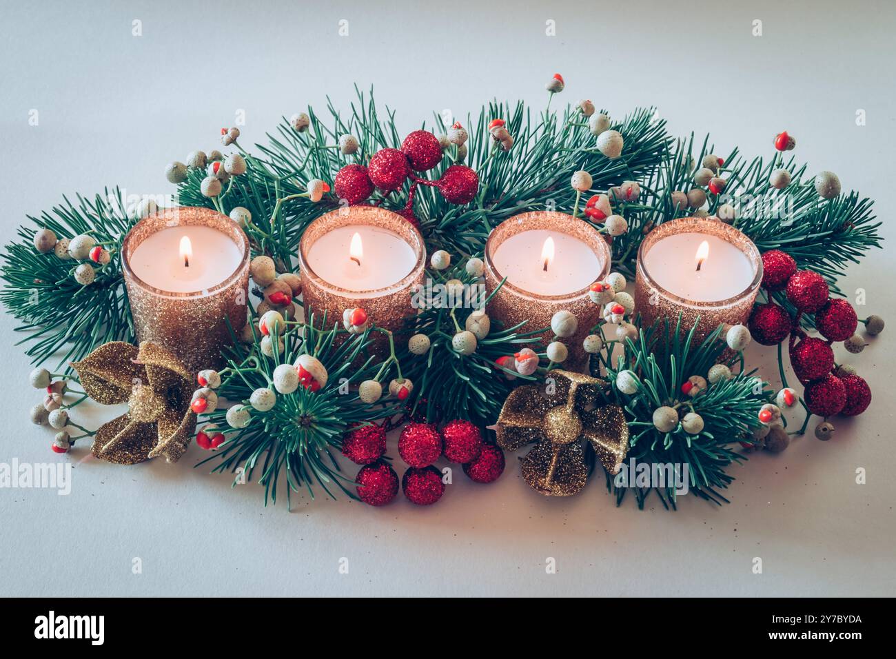 quattro candele bianche dell'avvento, decorazioni a corona con fiori e pino, isolate, quattro candele in fiamme Foto Stock