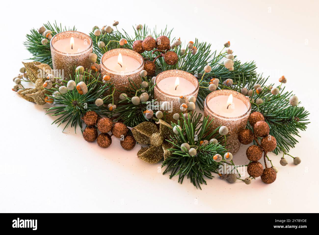 quattro candele bianche dell'avvento, decorazioni a corona con fiori e pino, isolate, quattro candele in fiamme Foto Stock