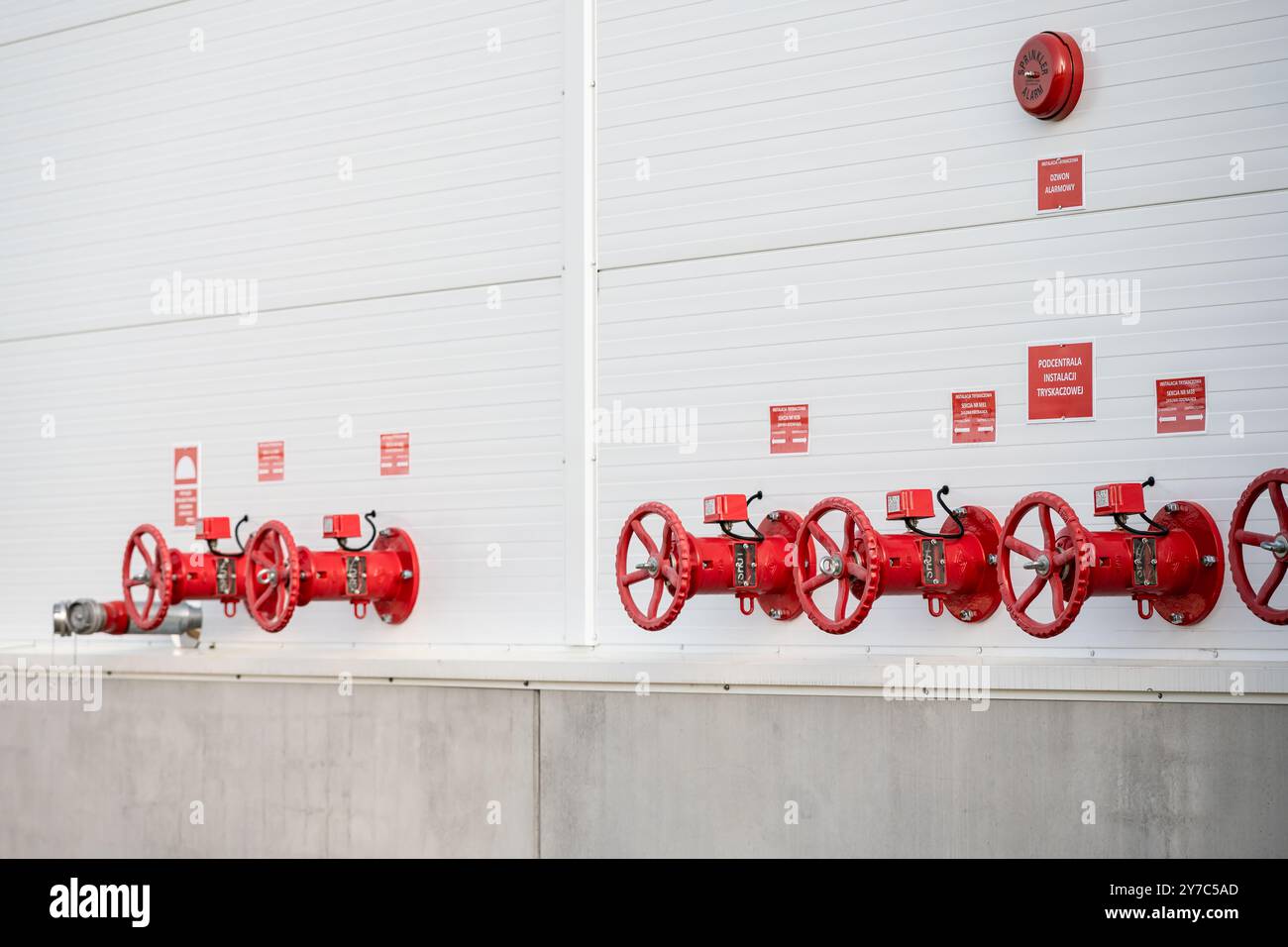 Fotografia ravvicinata delle valvole di controllo esterne dell'impianto sprinkler situate sulla parete esterna dell'impianto di produzione Foto Stock