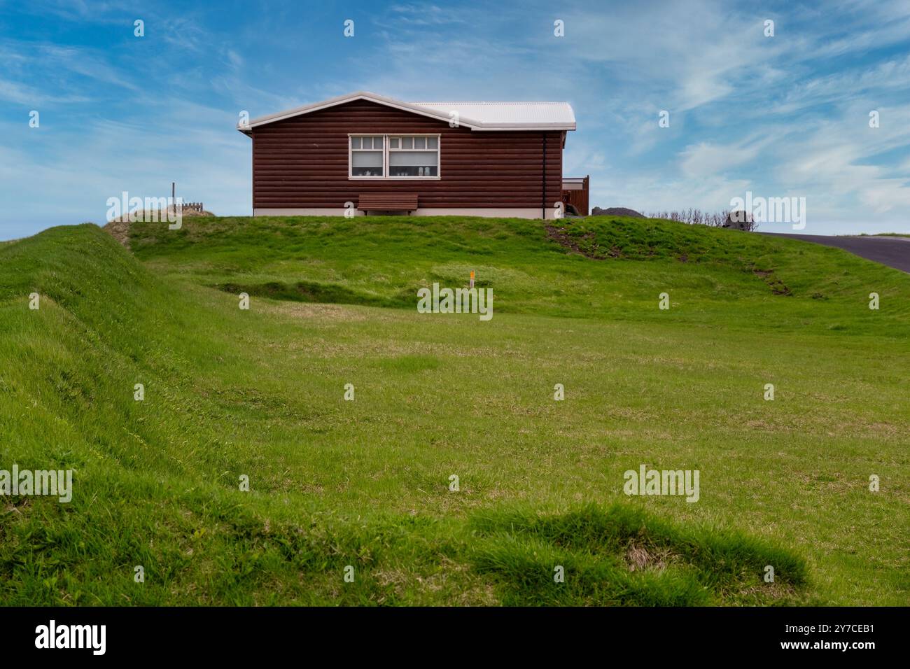 Appartato rifugio in legno tra le colline verdeggianti dell'Islanda - Una tranquilla fuga dal trambusto Foto Stock