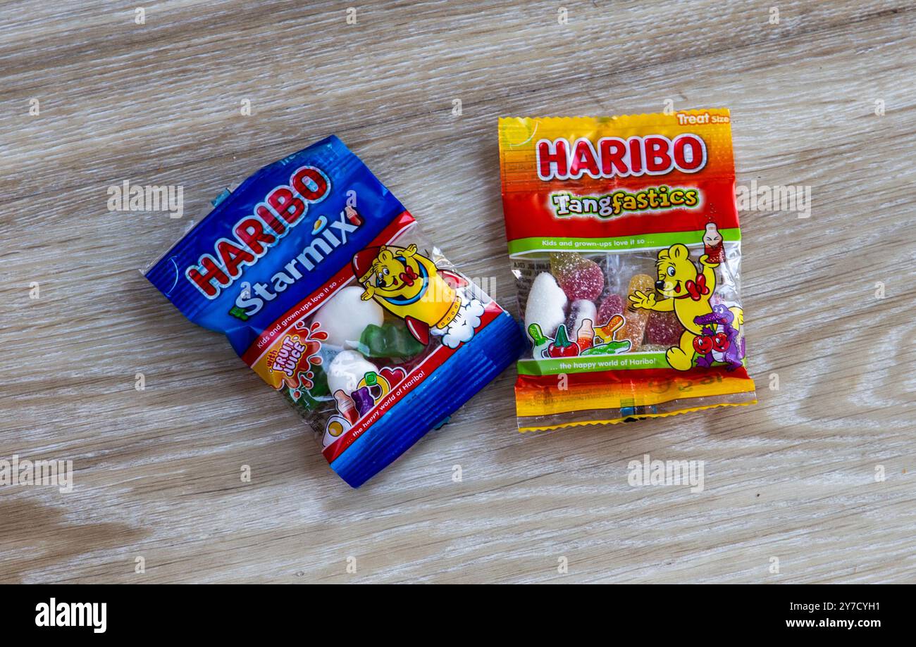 Due pacchetti di dolci Haribo, Starmix e Tangfastics, su una superficie in legno, che mostrano i famosi dolci gommosi e gelatina in confezioni colorate Foto Stock