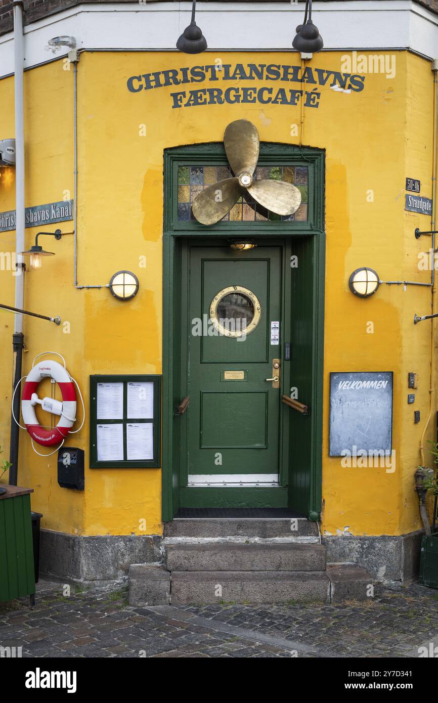 Porta d'ingresso verde con elica della nave, facciata dipinta di giallo, Christianshavns Faergecafe, Wilders Canal, Copenhagen, Danimarca, Europa Foto Stock