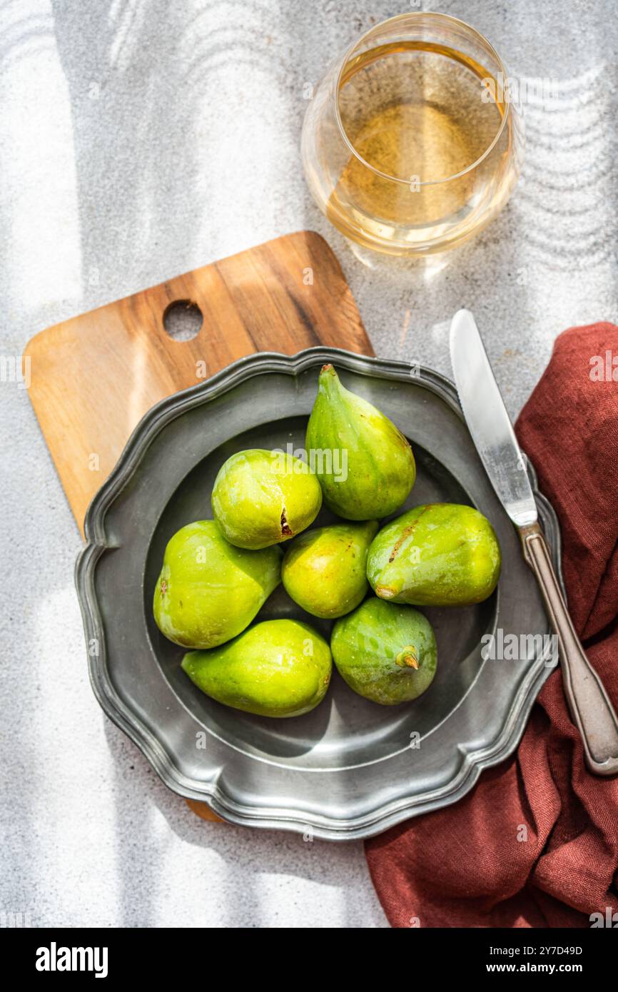 Fichi verdi maturi e formaggio Brie serviti con vino bianco secco per un aperitivo a cena Foto Stock