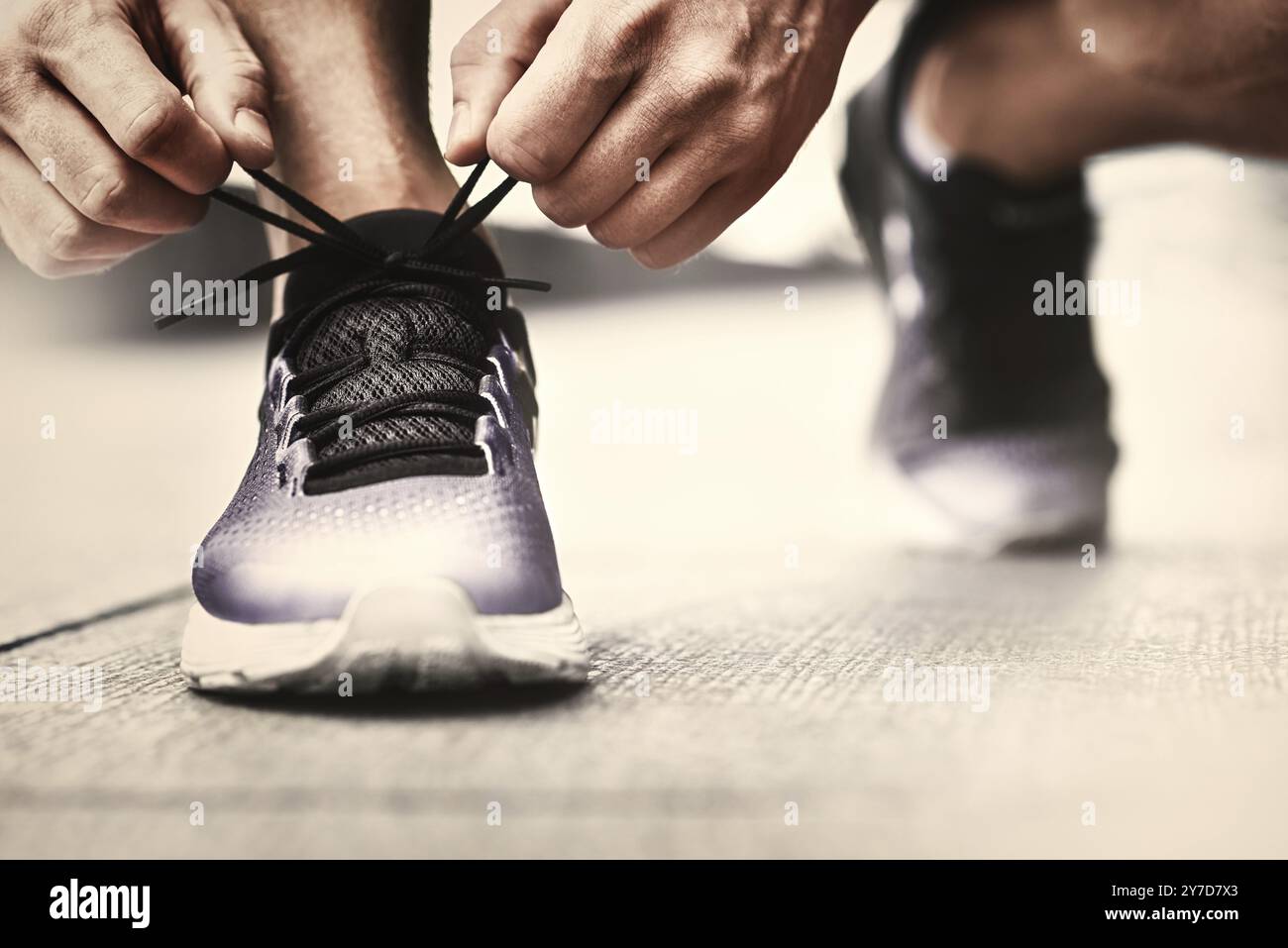 Immagine ritagliata di mani lacci delle scarpe di legatura su sneaker, superficie in esecuzione sullo sfondo. Le mani di uno sportivo con contapassi lacci delle scarpe di legatura su sneaker sportiva. Ru Foto Stock