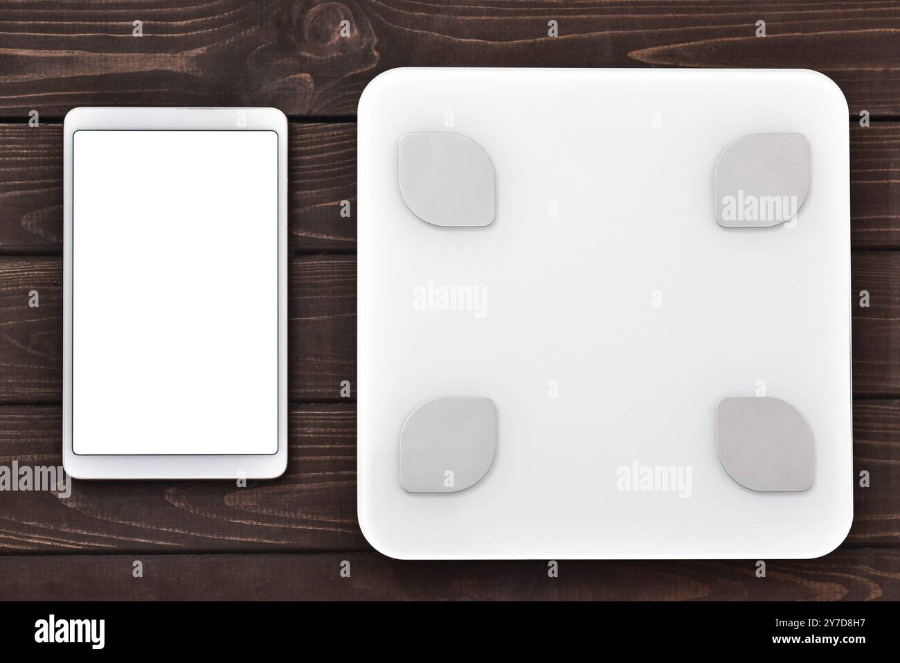 Indice glicemico concetto di fitness e perdita di peso, scala bianca e tablet su tavolo in legno, vista dall'alto Foto Stock