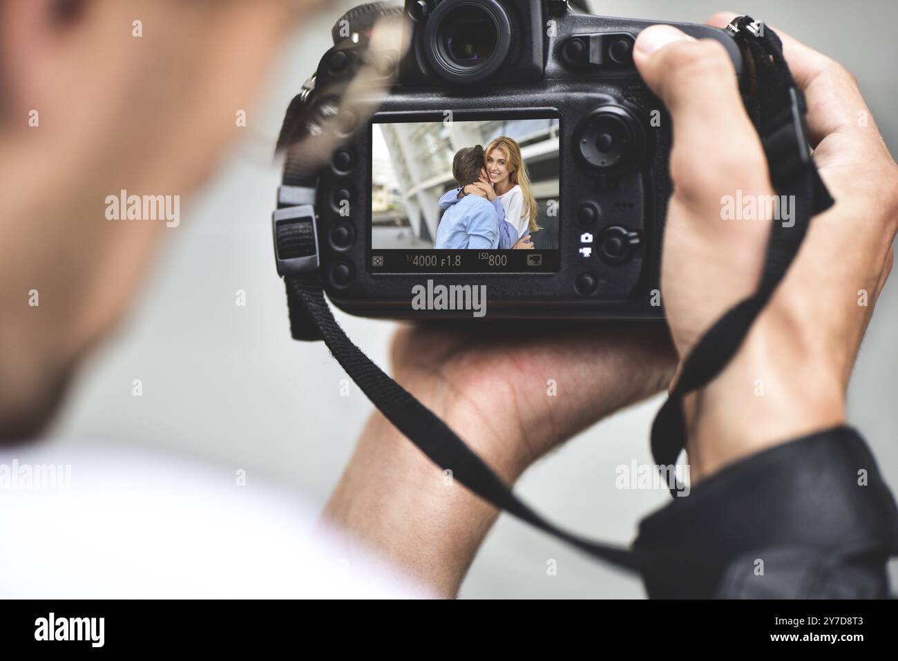 Digital single lens reflex in mani. Fotografo mani riprese da vicino. L'uomo fotografo rende le foto per la fotografia stock. Maschio di tenere le mani Foto Stock
