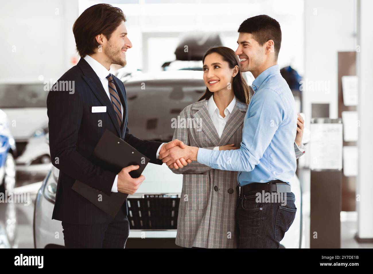 Uomo Che Si Stringe Le Mani Con Il Responsabile Delle Vendite Di Auto Nel Dealership Store Foto Stock