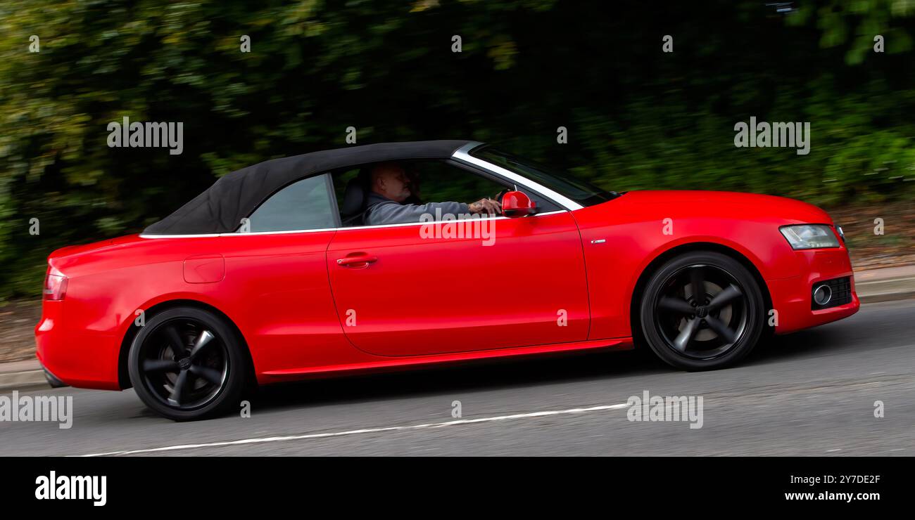 Milton Keynes, Regno Unito - 29 settembre 2024: 2011 auto Audi A5 rossa che guida su una strada britannica Foto Stock