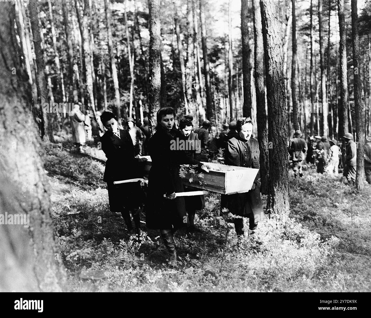 Le donne tedesche trasportano un cadavere trovato nel bosco vicino a Neunburg Vorm Wald al cimitero cittadino per una corretta sepoltura. Le vittime erano ebrei polacchi, ungheresi e russi uccisi vicino a Neunburg durante una marcia della morte da Flossenbuerg. Azioni come questa facevano parte del processo di denazificazione. Questo processo fu un tentativo di liberare la cultura e la società tedesca e austriaca dall'influenza e dall'ideologia nazista. Una parte del processo prevedeva di affrontare il pubblico con le prove dei crimini commessi nella loro zona. Foto Stock
