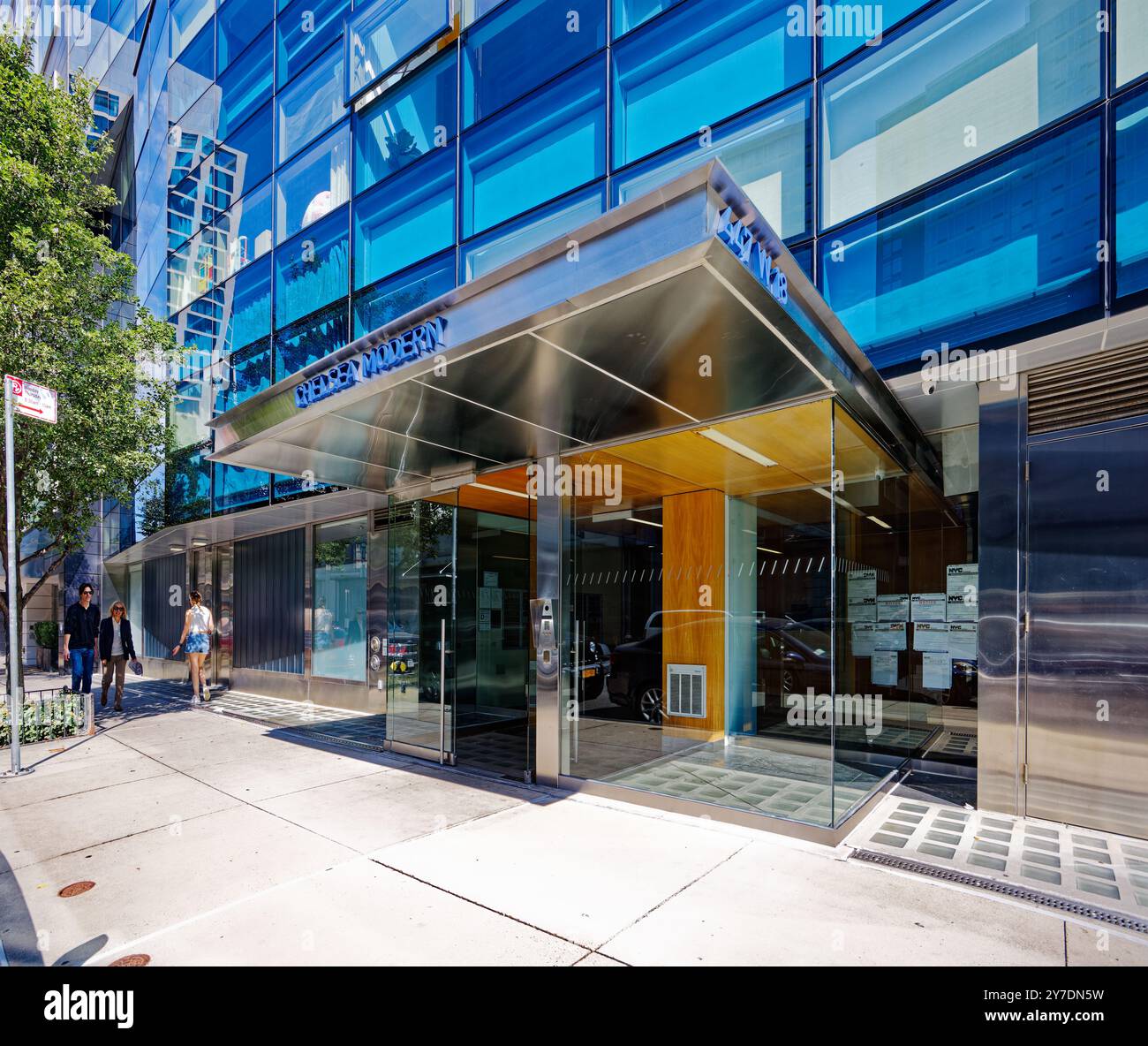 Un elegante tendone in acciaio inossidabile ripara l'ingresso del vestibolo del Chelsea Modern, gli scintillanti strati a zig-zag di vetro blu e bianco di Audrey Matlock. Foto Stock
