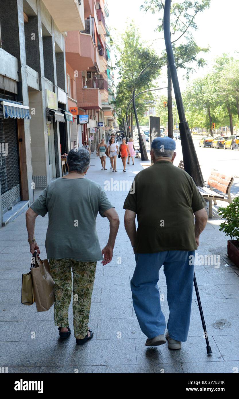 Una coppia catalana anziana che cammina sul Trav. De Dalt a Gràcia, Barcellona, Spagna. Foto Stock