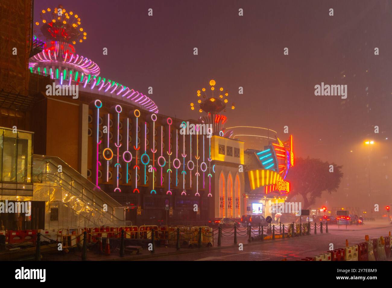 Il Casino Lisboa Neon si illumina sotto la pioggia, con il paesaggio stradale di Macao in tifone Foto Stock