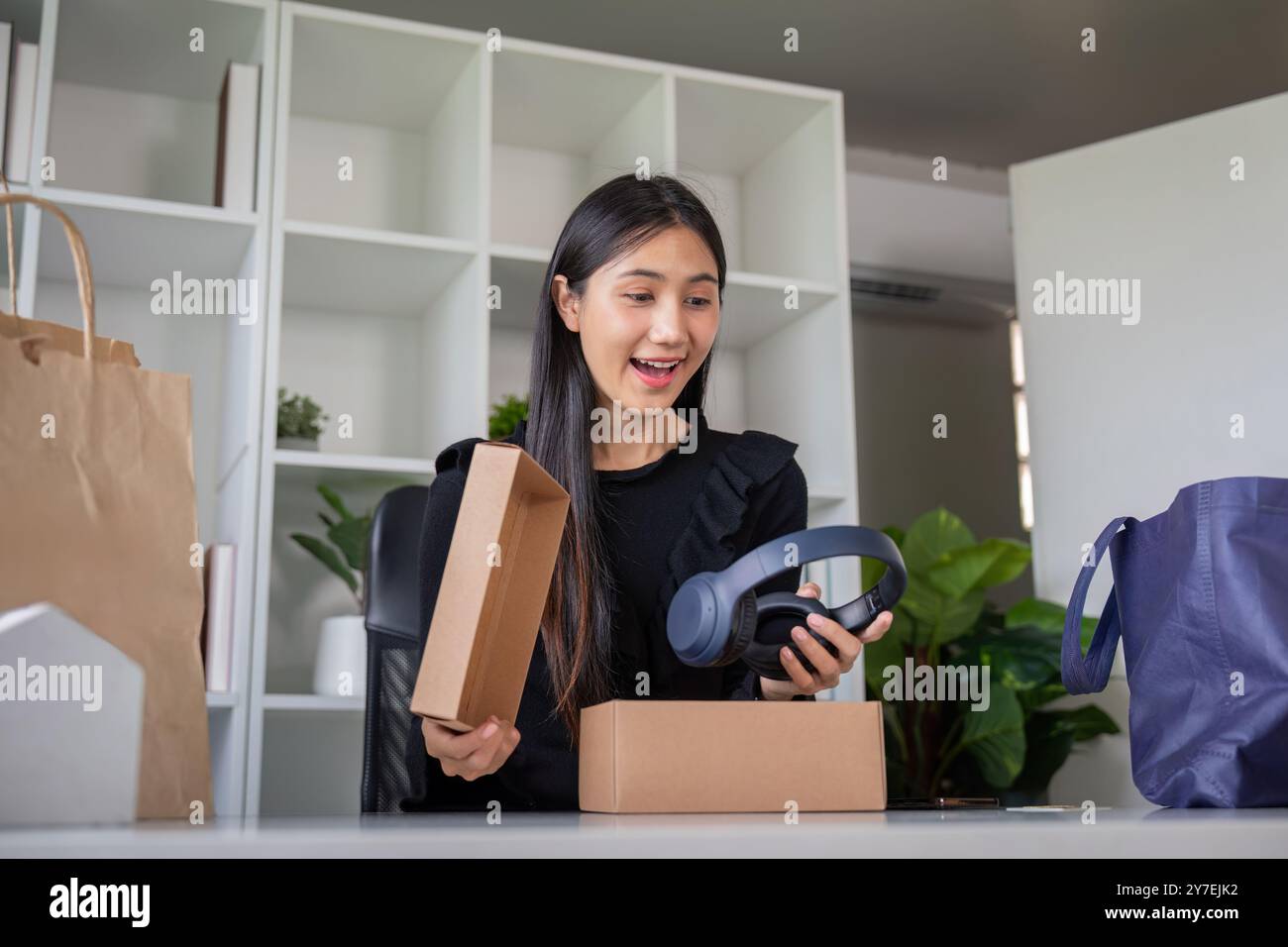 Un acquirente entusiasta che scopre nuove cuffie nel pacchetto Foto Stock